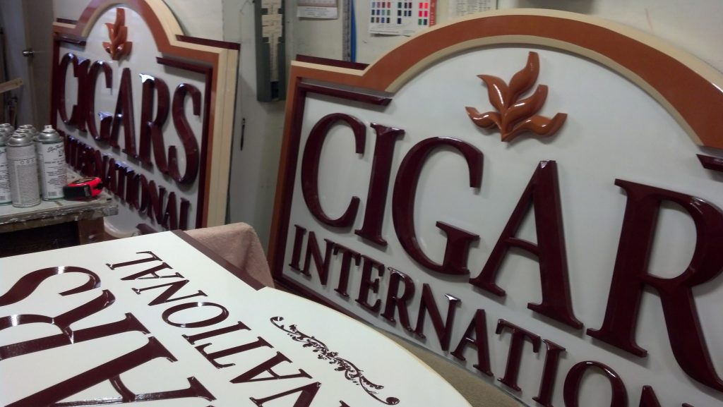 Cigars International is a HDU dimensional sign with applied cut out prizm letters, graphic & borders